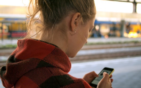 Young woman walking looking at her phone